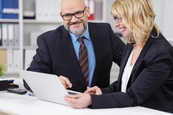 Smiling executives at work together behind desk — Stock Photo, Image