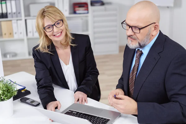 Lyckliga affärsfolk på jobbet bakom skrivbordet — Stockfoto