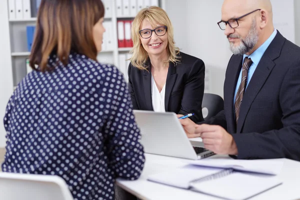 Tre ledande befattningshavare i möte runt laptop — Stockfoto