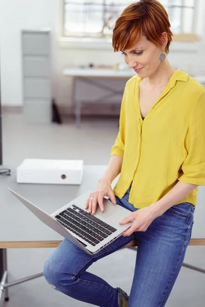 Mulher trabalhando no laptop a partir da borda da mesa — Fotografia de Stock