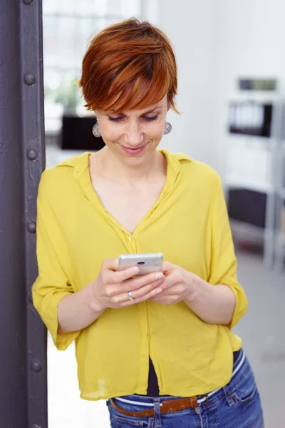 Attractive casual young woman reading an sms — Stock Photo, Image