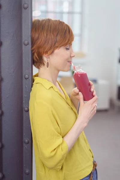 Aantrekkelijke jonge vrouw genieten van een lang koud drankje — Stockfoto