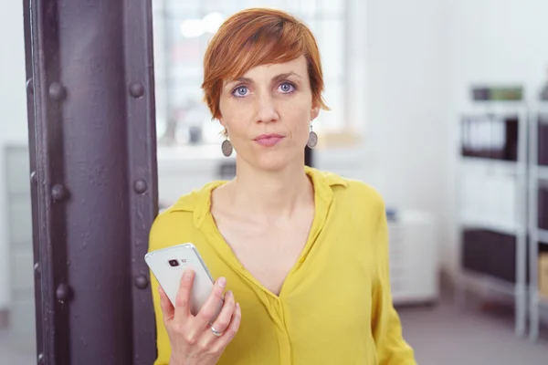 Serious young red haired woman in yellow blouse — Stock Photo, Image