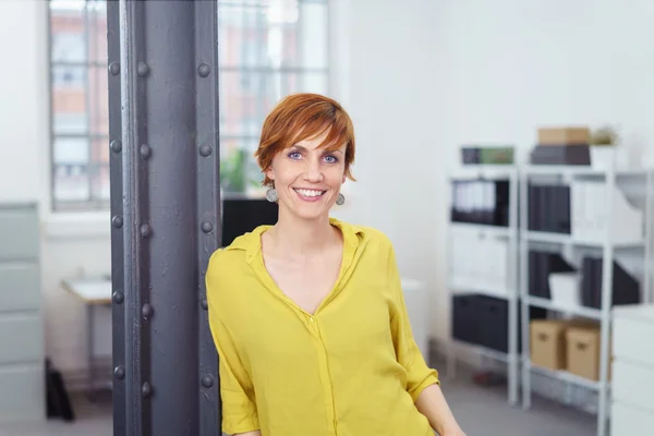 Küçük ofis içinde yazı üzerine eğilerek tek kadın — Stok fotoğraf
