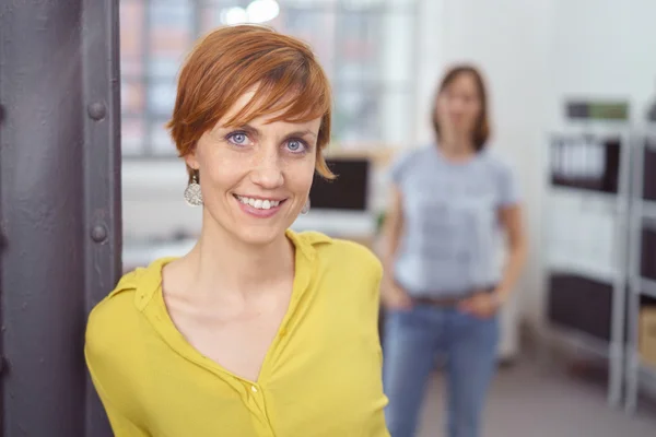 Nette junge Frau mit Partner im Hintergrund — Stockfoto