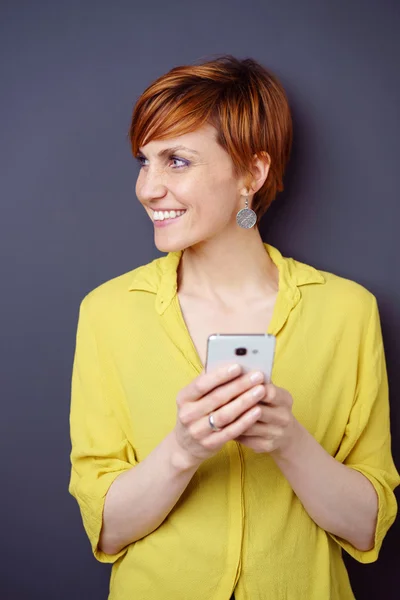 Bella amichevole giovane donna in possesso di un cellulare — Foto Stock