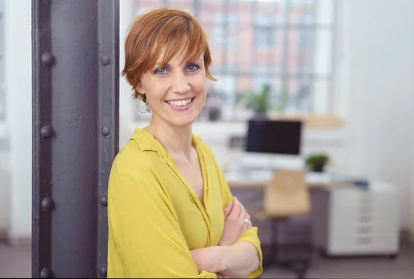 Frau mit verschränkten Armen in kleinem Büro — Stockfoto