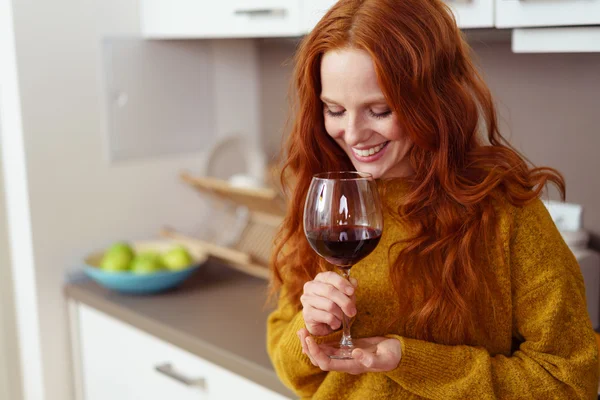 Mulher sorridente cheirando vinho em vidro — Fotografia de Stock