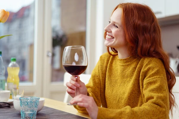 Linda mulher segurando vinho à mesa — Fotografia de Stock