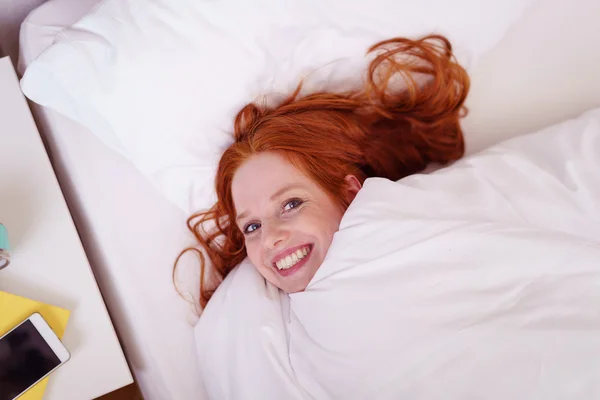 Linda mujer vivaz abrazándose en su cama — Foto de Stock