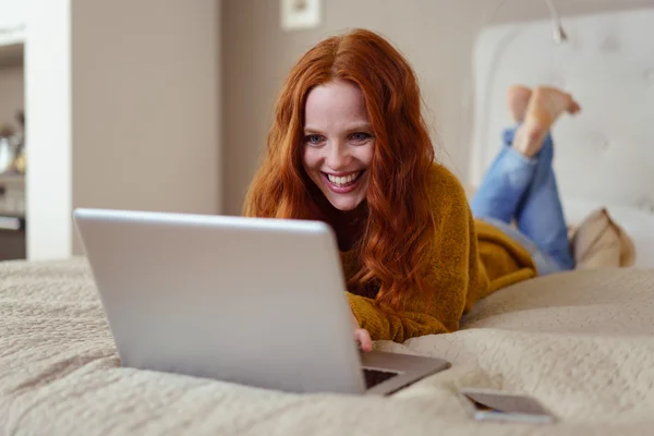 Woman enjoying something on her laptop — Stockfoto