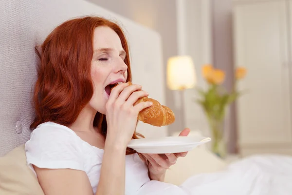 Attraktiv rödhårig kvinna njuter av frukost i sängen — Stockfoto