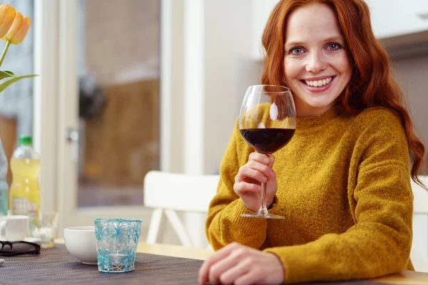 Mulher atraente segurando vinho na mesa — Fotografia de Stock