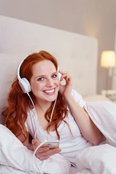 Mujer pelirroja bonita escuchando música — Foto de Stock