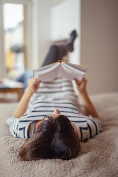 Mujer joven relajándose con un libro en casa —  Fotos de Stock