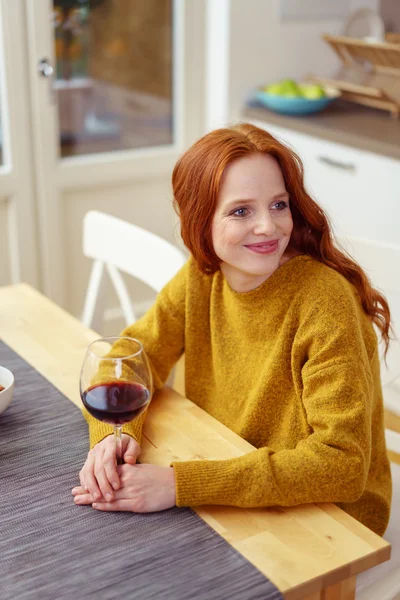Smiling woman at table with wine — Stock fotografie