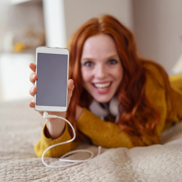 Щаслива жінка, що показує порожній смартфон — стокове фото