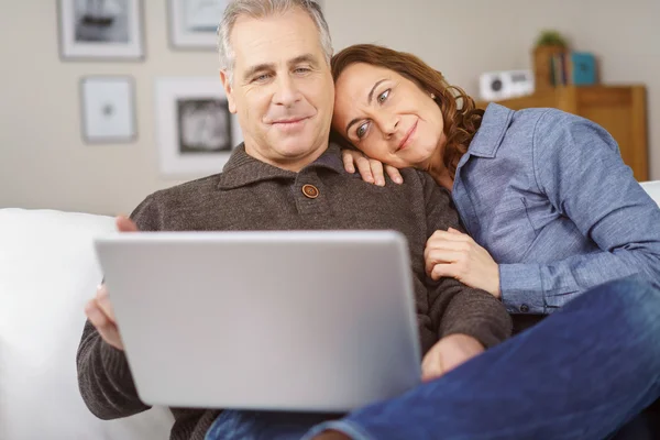 Happy middle aged couple on couch with laptop — Stock Photo, Image