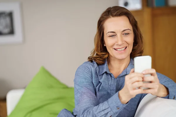 Aantrekkelijke vrouw het lezen van haar SMS-berichten — Stockfoto