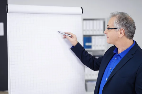 Single businessman pointing at chart with pen — 图库照片