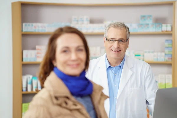 Farmacêutico masculino amigável ajudando uma mulher — Fotografia de Stock