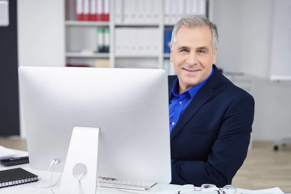 Handsome businessman working at a desktop — Stock Photo, Image