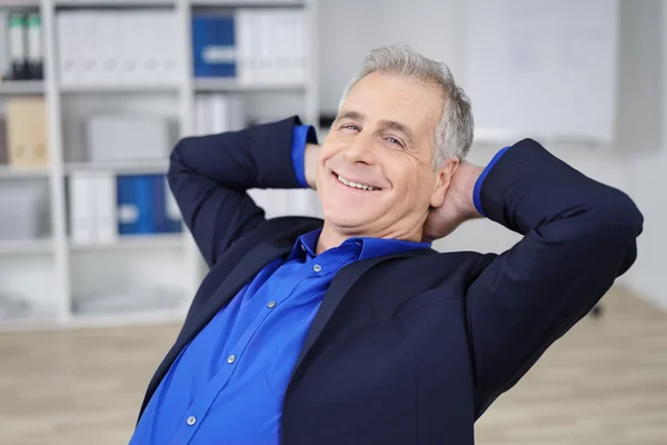 Ontspannen zelfverzekerde zakenman met een stralende glimlach — Stockfoto