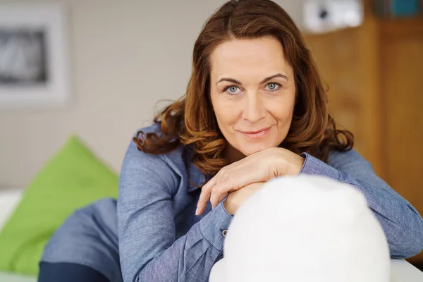 Attractive middle-aged woman relaxing on a sofa — Stock Photo, Image