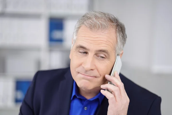 Dubious businessman listening to a phone call — Stock Photo, Image