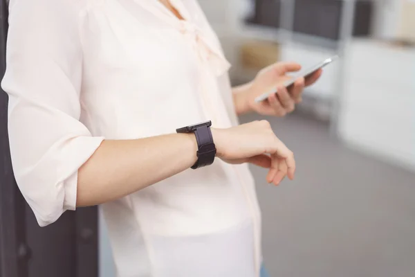 Mujer revisando su reloj de pulsera para el momento — Foto de Stock