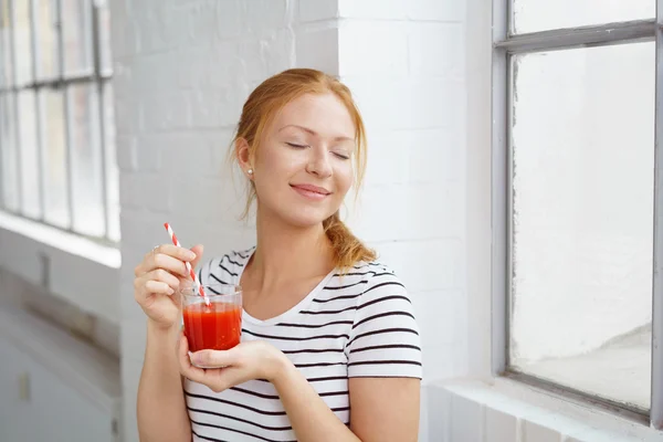 Cabeza roja bastante joven disfruta de su bebida — Foto de Stock