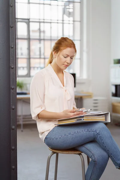 Mujer joven y seria trabajando en documentos — Foto de Stock