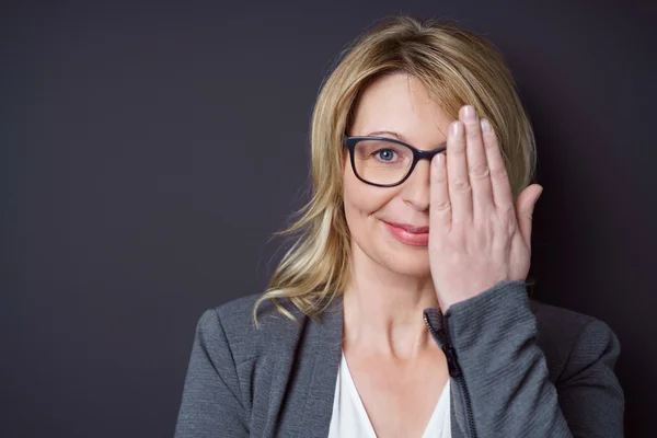 Alleenstaande vrouw in brillen die één oog bedekken — Stockfoto