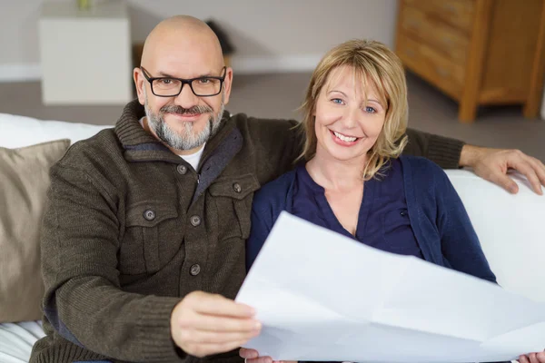 Vacker skallig man och hans fru sitter på soffan — Stockfoto