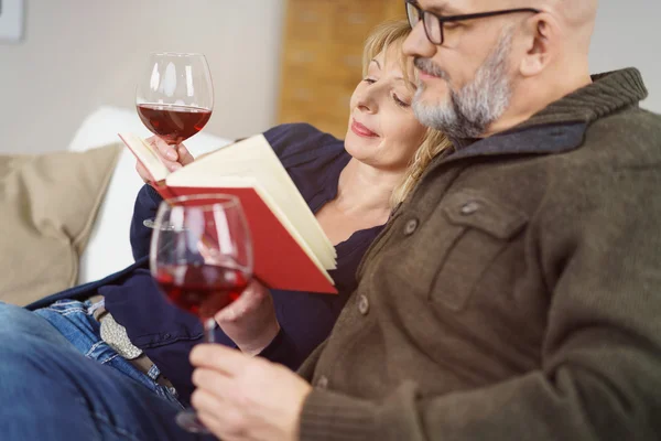Casal de meia-idade relaxante desfrutando de um livro — Fotografia de Stock