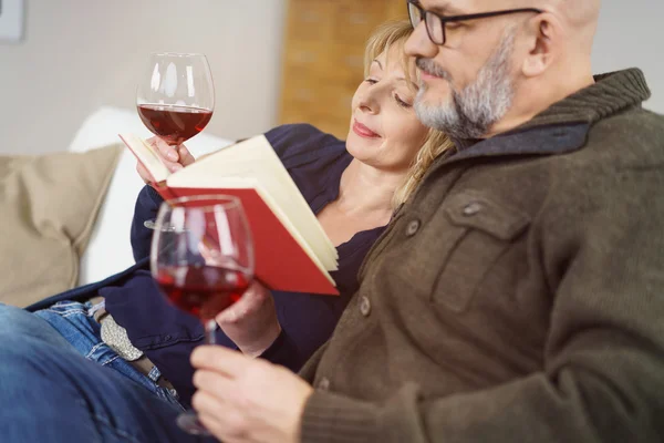 Pareja de mediana edad relajándose disfrutando de un libro —  Fotos de Stock