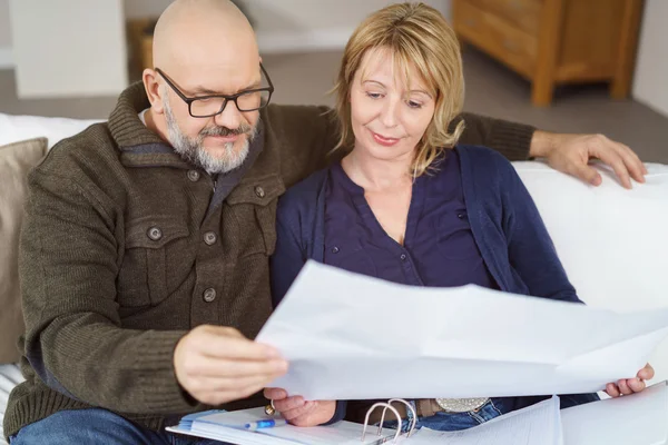 Skallig man på soffan med en arm runt sin fru — Stockfoto