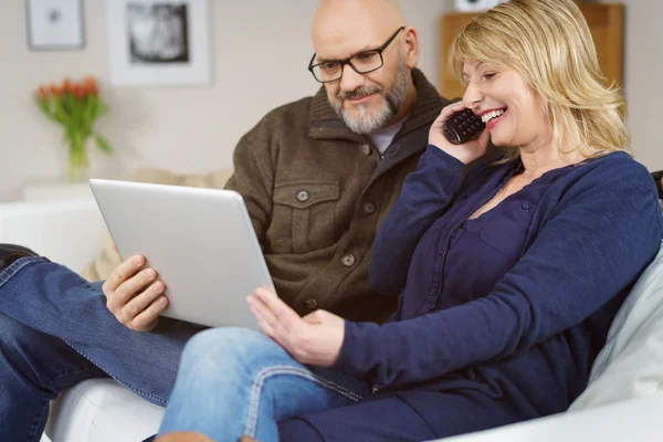 Casal feliz no suporte telefônico com computador — Fotografia de Stock