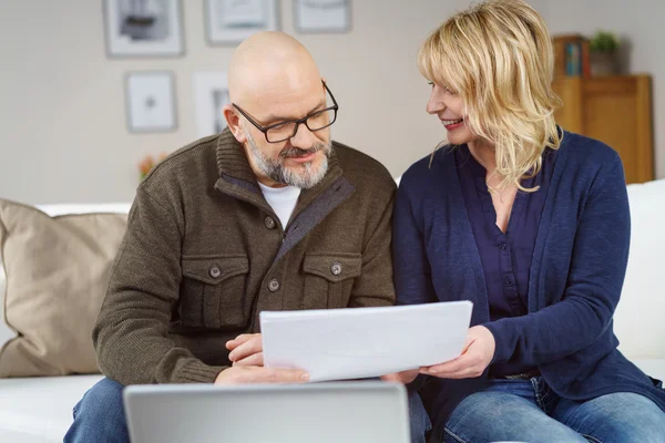 Bald man and wife on couch in living room — Stock Photo, Image