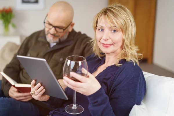Calm mature couple drinking wine and reading — Stock Photo, Image