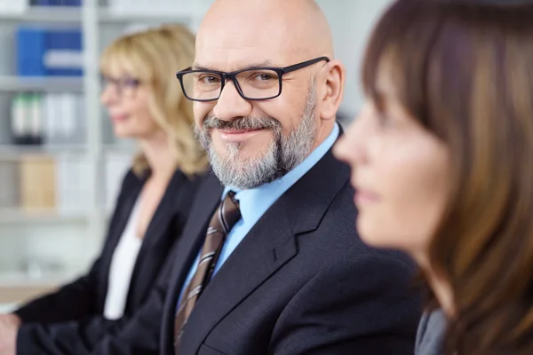 Homme chauve avec des lunettes et portant un costume d'affaires — Photo