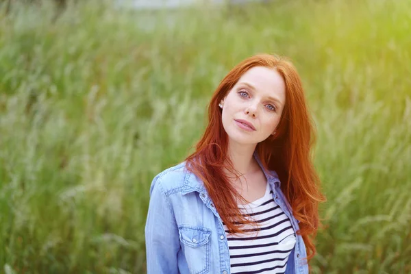 아름다운 젊은 빨강 머리 여자 에 a 잔디 필드 — 스톡 사진