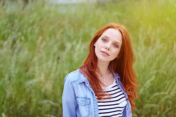 Linda jovem ruiva em um campo gramado — Fotografia de Stock