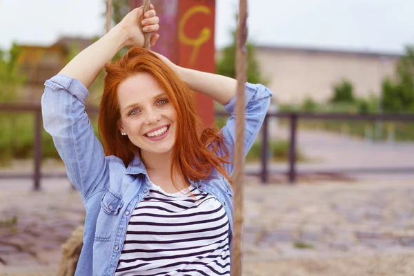 Mulher feliz sentado no balanço do parque — Fotografia de Stock