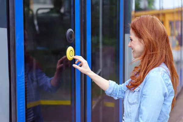 Enda kvinna trycka på knappen på spårvagns dörr — Stockfoto