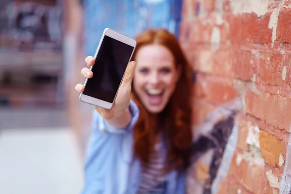 Mujer joven emocionada mostrando su móvil — Foto de Stock