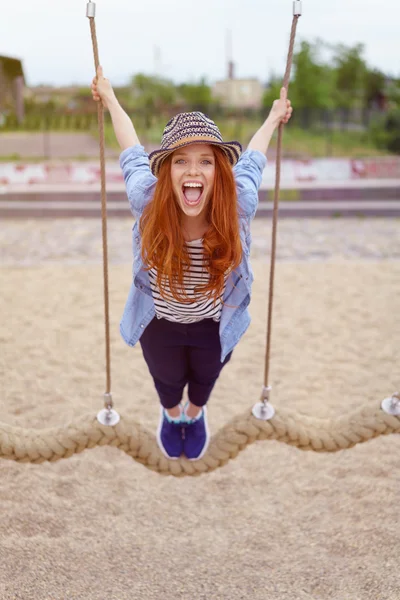 Young redhead woman laughing as she leans forwards — 图库照片