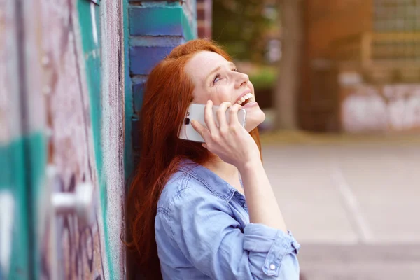 Mujer joven riendo mientras charla en un móvil —  Fotos de Stock