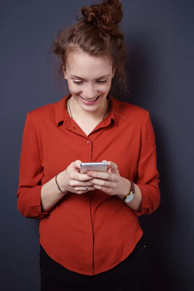 Heureuse femme célibataire textos avec son téléphone — Photo