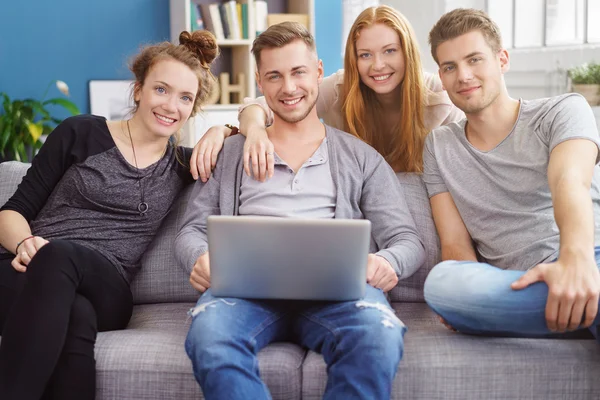 Grupo de amigos felizes trabalhando no computador portátil — Fotografia de Stock